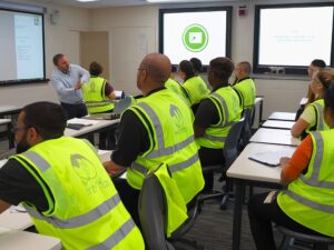 classroom 7 employees wearing green vests watching training video 621955 46848