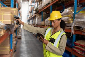 female worker scanning package with barcode scanner while using digital tablet warehouse 13339 356156