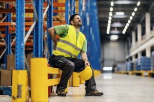 warehouse worker having back pain rubbing it 232070 17765 1
