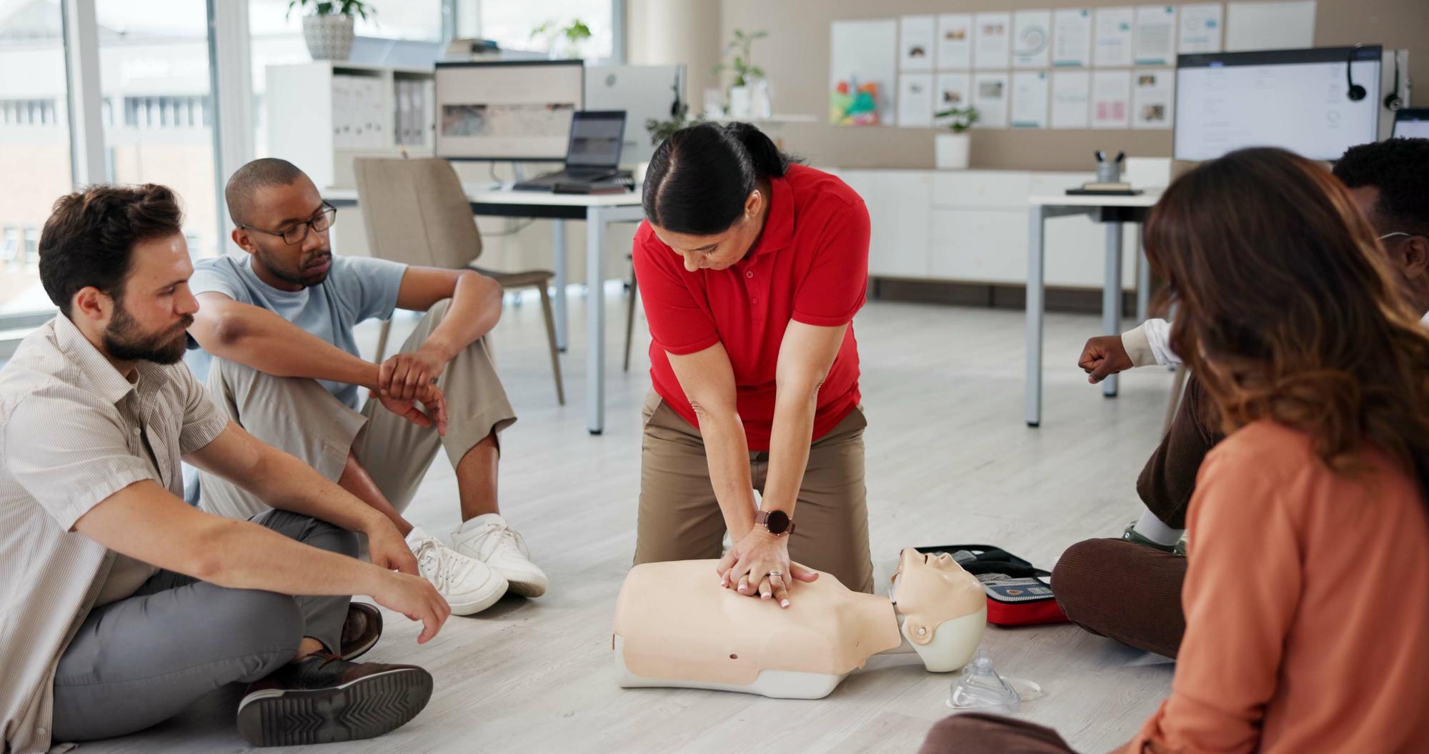 first aid cpr training people with dummy safety compliance health chest compression breathing paramedic course medical demonstration teaching emergency rescue technique office 590464 525199